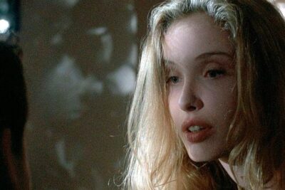 Close-up contemplative portrait of a young woman with long blonde hair and soft lighting suggesting a igualdade