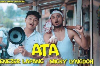 Two men holding a frying pan and a rolling pin in a lively outdoor market scene