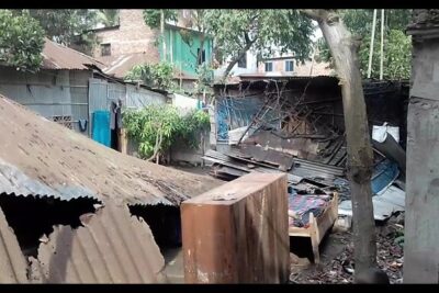 Cluster of rusted corrugated metal shacks and scattered debris forming an a vare 4 makeshift settlement