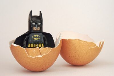 Lego Batman minifigure emerging from cracked eggshells as a quirky illustration for abortdebatt for och emot abort en kontroversiell fragga