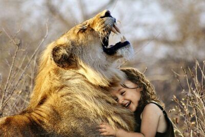 Young child hugging a calm lion, a visual metaphor for abortfragan argument for och emot abort en djupgaende analys.