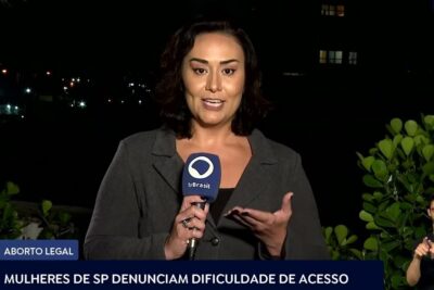 Nighttime field reporter holding a microphone during live broadcast about aborto legal 13