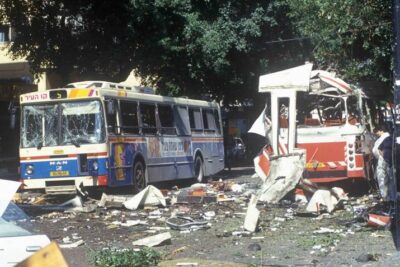 Two heavily damaged city buses surrounded by scattered debris and shattered glass after an explosion, af terrorisme 1.