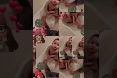 Infant sitting in a small bathtub surrounded by heart stickers and a tiled collage featuring aidin vauvan