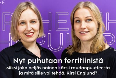 Two smiling women posed against a purple backdrop with bold Finnish text about ferritin and women's iron deficiency, indicating that low levels aiheuttaa merkittavaa.