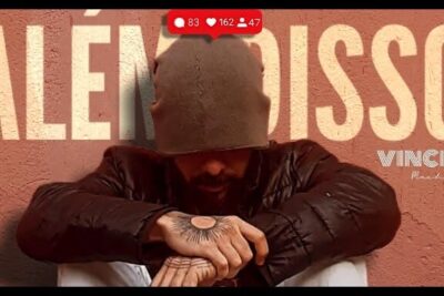 Seated person in a beanie and puffer jacket with a sun tattoo on the hand, set against bold 'alem disso 80' lettering