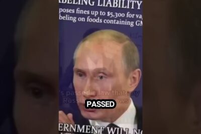 Close-up of a male speaker in a suit with a 'PASSED' overlay and a backdrop referencing labeling and liability, alimenti transgenici 1