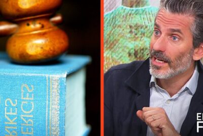 Studio commentator gesturing beside a gavel on a law book discussing allvarliga brott