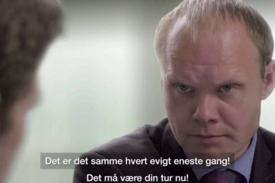 A stern-looking man in a suit engaged in a tense office conversation, alternative metoder 2