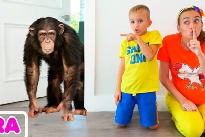 Chimpanzee standing in a doorway beside a kneeling adult and child in a colorful room, animal compagnie scene.