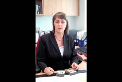 Professional at an office desk with cigarette packs discussing anti smoking laws
