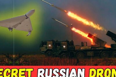 Triangular surveillance drone flying over a rocket artillery vehicle firing rockets, illustrating anvanda dronar.