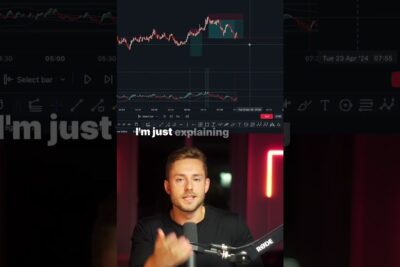 Presenter speaking into a microphone beneath a candlestick trading chart illustrating apent handelssystem 1.
