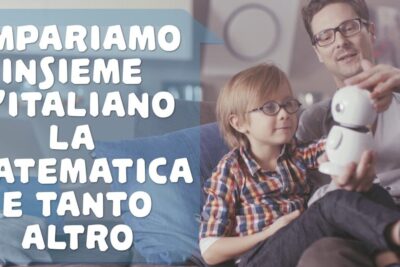 An adult and child on a sofa exploring a small white educational robot for apprendimento interattivo while practicing Italian and math together.