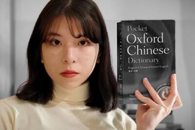 Woman holding a Pocket Oxford Chinese Dictionary to aprender idioma 1.
