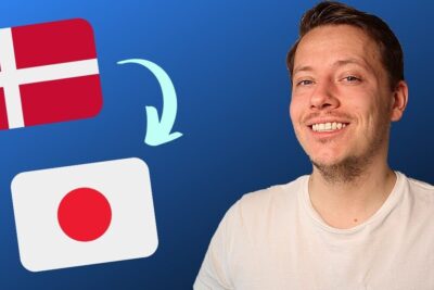 Smiling man beside Danish and Japanese flags with an arrow indicating arbejde udlandet transition