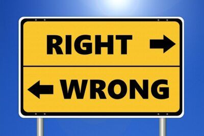 Yellow road sign reading 'RIGHT' with right arrow and 'WRONG' with left arrow illustrating argument for och emot mansklig experimentering en djupgaende analys.