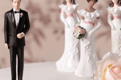 Groom cake topper standing apart from three bride toppers, a staged scene hinting at argumentos poliamor