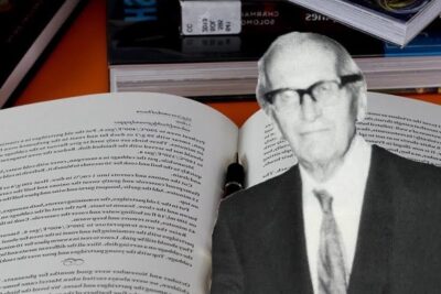 Open book, fountain pen and a black-and-white paper portrait suggesting academic argumentos positivismo.