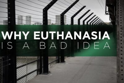 Large urban banner reading Why euthanasia is a bad idea on a fenced walkway, illustrating arguments euthanasia against assisted dying.