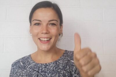 Smiling woman giving a thumbs up, suitable for arguments juridiques and legal content.