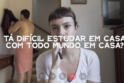 Young woman on a video call studying at home amid household distractions and a background figure, highlighting the challenge of remote study and need for aulas presenciais