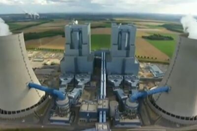 Aerial view of large power plant cooling towers emitting steam illustrating auswirkungen umwelt