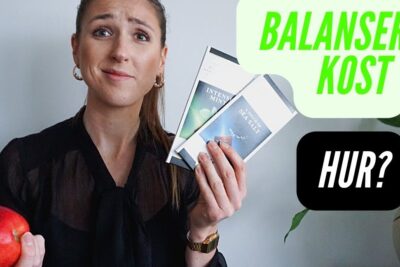 Person holding an apple and packaged snack bars with overlay text balanserad kost 1