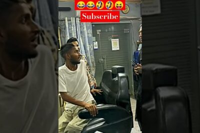 Man seated in a barber chair talking to a stylist inside a barer burkaen barbershop.