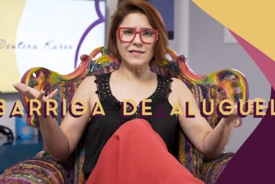 Woman with red glasses seated in a colorful armchair speaking about barriga aluguel 2 during an interview