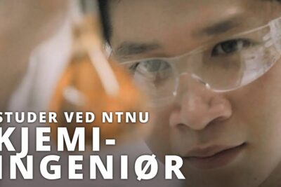 Close-up of a laboratory student wearing safety goggles inspecting an amber sample, illustrating bioteknologiske prosesser.