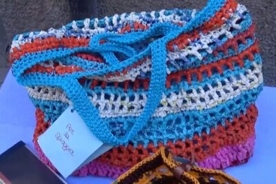Bright handwoven beach tote crafted from recycled plastic strips, borse plastica style