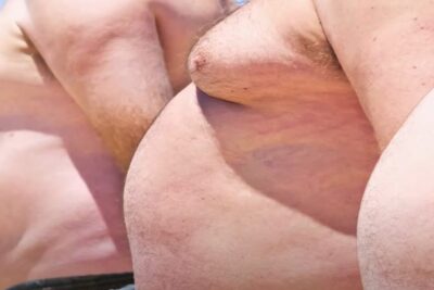 Close-up of sunlit bare male torsos showing chests and upper abdomens brugen gmoer