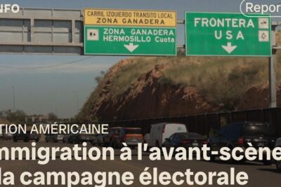 Line of cars queued at a border crossing beneath green overhead signs reading 'Frontera USA', representing cross-border travel canada etats unis
