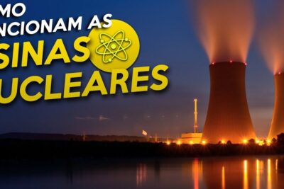 Two illuminated nuclear cooling towers at night with steam plumes and bright reflections on water, centrais nucleares 1.