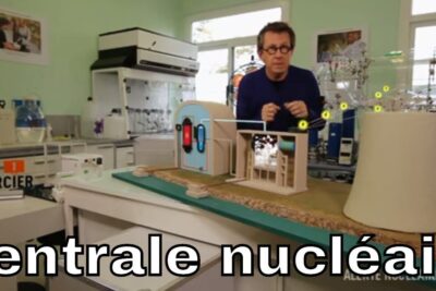 Laboratory demonstration with a tabletop model of a nuclear power plant labeled centrales nucleaires 1.
