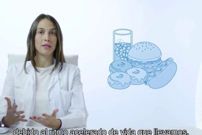 Female clinician in a white coat beside an illustration of comida chatarra 2 featuring a burger, hot dog, donuts and a soda.