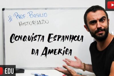Bearded instructor gestures toward a whiteboard titled 'Conquista Espanhola da America' in a conquista espanhola 1 educational thumbnail.