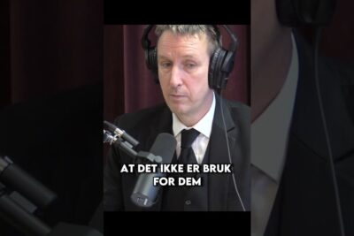 Man in a suit wearing headphones speaking into a studio microphone for dagens samfunn.