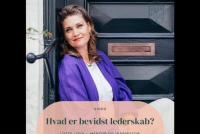 Professional woman in a purple blazer seated by a dark door, reflecting on darligt lederskab.
