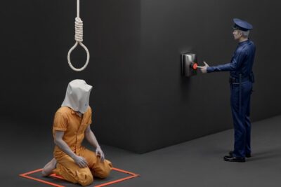 A hooded inmate in an orange jumpsuit kneels under a hanging noose while a uniformed officer presses a red button in a death penalty 3 scene.