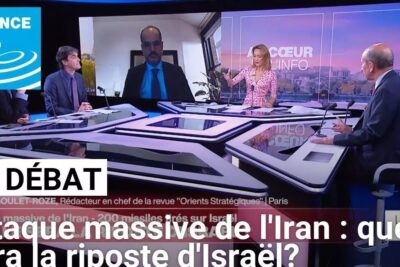Television news studio roundtable with host and panelists in discussion, debat politique 1.