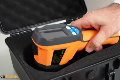 Hand placing an orange handheld thermal imager into a foam-lined protective case, illustrating dellavanzamento tecnologico.