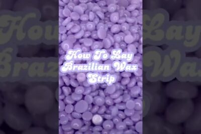 Close-up of purple wax beads with overlay text 'How To Lay Brazilian Wax Strip' showing depilazione intima 1.