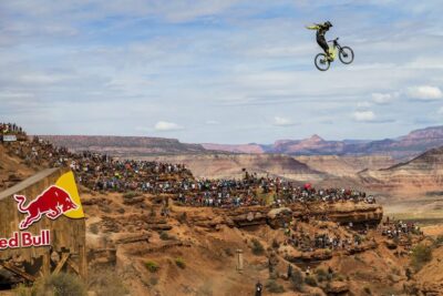 Deportes extremos 1: Spectacular Canyon Big-Air Mountain Biking Event featuring a cyclist airborne above a canyon crowd and Red Bull branding.