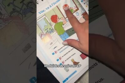 A hand points to a colorful workbook illustration of a boy brushing his teeth at a sink, part of devoirs scolaires 3.