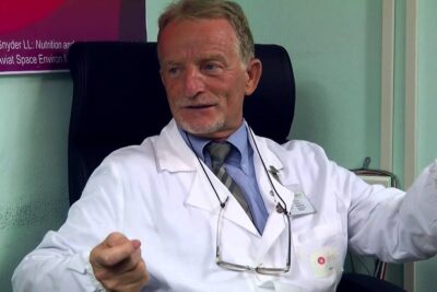 Medical professional in a white coat discussing dieta equilibrata and healthy eating during a consultation.