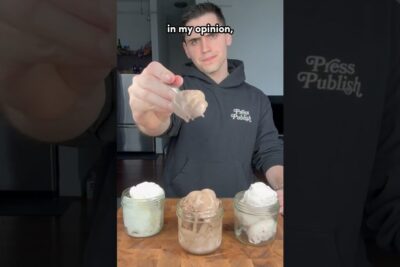 Man holding a spoonful of chocolate ice cream toward the camera above three jarred ice cream scoops, dodsstraffet ar 1