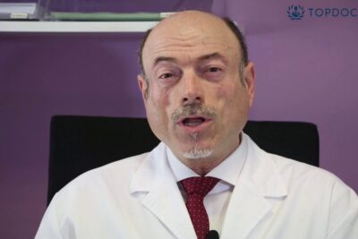 Male medical professional in a white coat speaking about dolor cronico 10