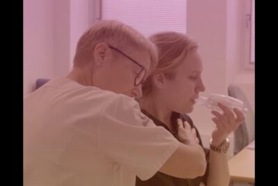 Caregiver embracing and supporting a woman using a nebulizer mask, donera organ
